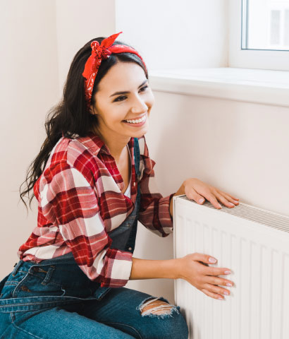 Person sitzt entspannt am Heizkörper